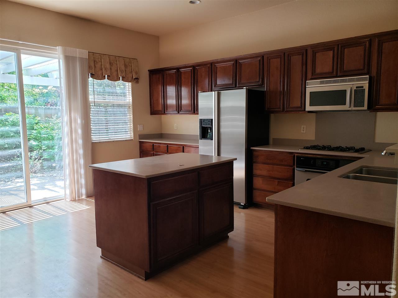 1680 Emerald Bay Drive Reno, NV 89521 - Photo 7 of 27 a kitchen with stainless steel appliances granite countertop a stove a sink and a refrigerator