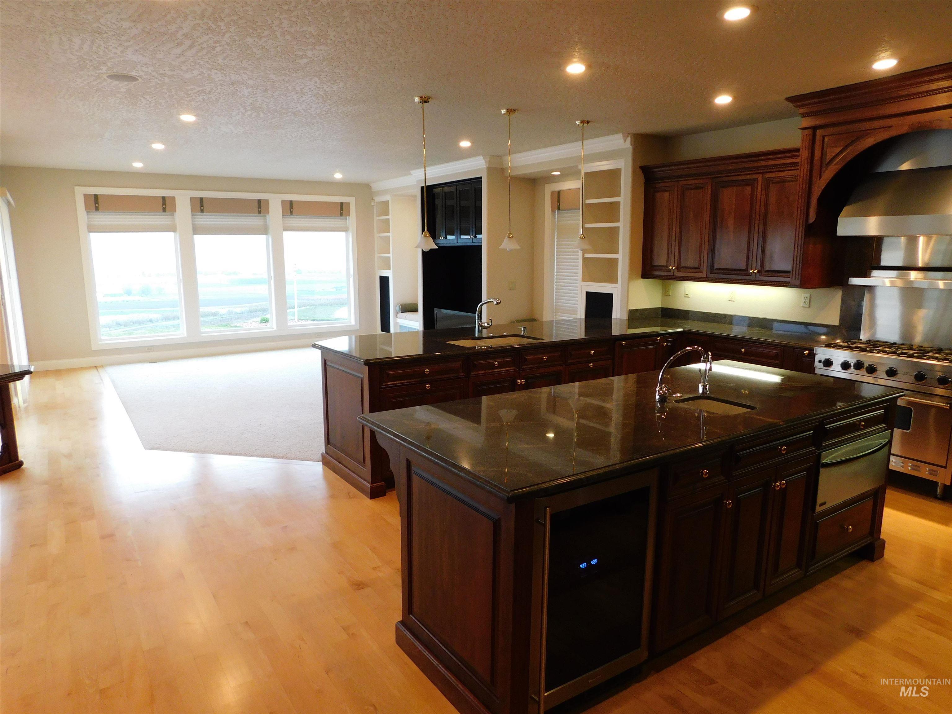 17777 Allendale Road Wilder, ID 83676 - Photo 12 of 50 Kitchen featuring wine cooler, a textured ceiling, an island with sink, high end stainless steel range, and Cherry wood cabinets