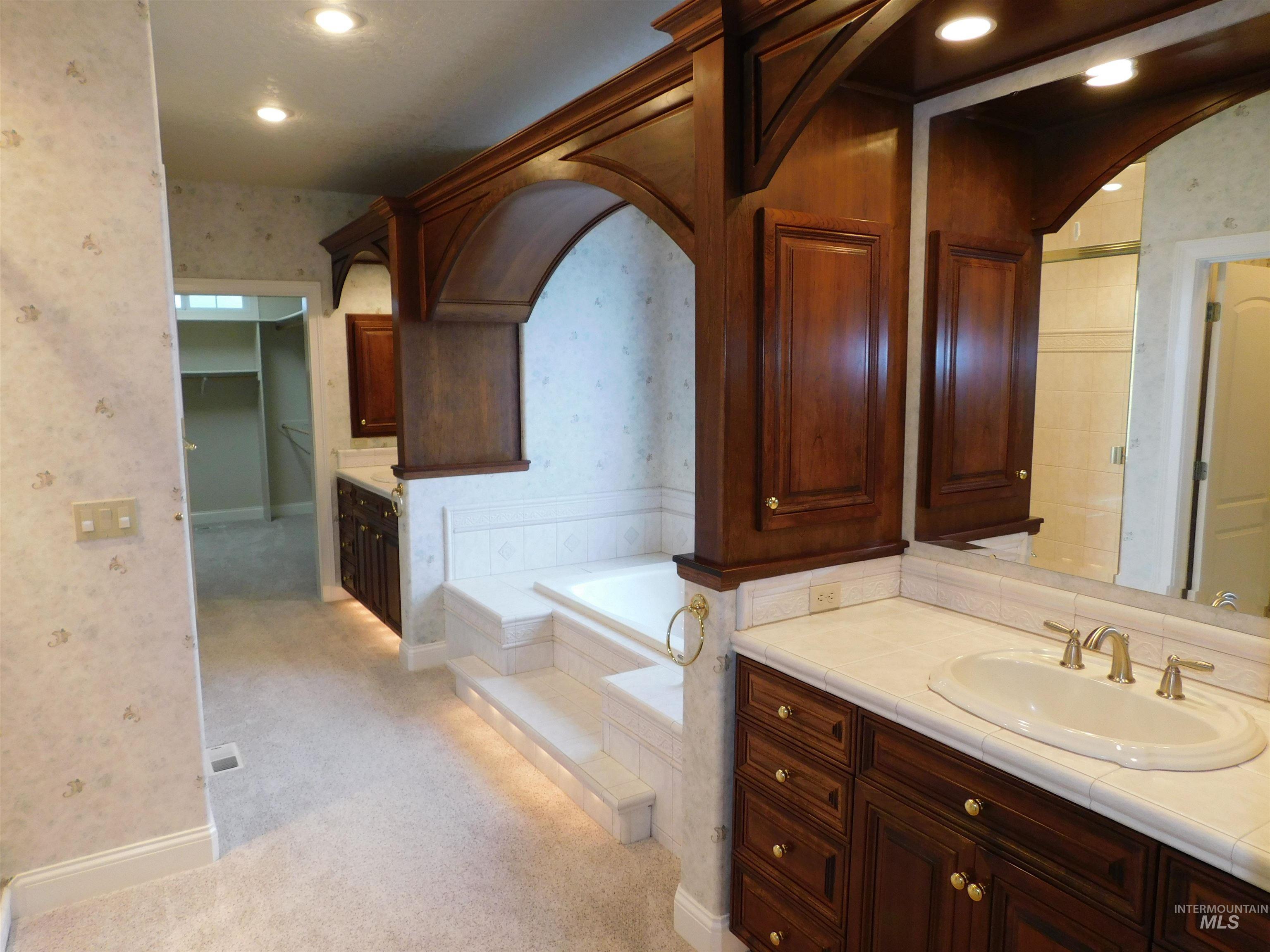 17777 Allendale Road Wilder, ID 83676 - Photo 16 of 50 Bathroom featuring wallpapered walls, vanity, light carpet, a garden tub, and recessed lighting, soaker tub. steam/sauna shower/ his and hers closets.