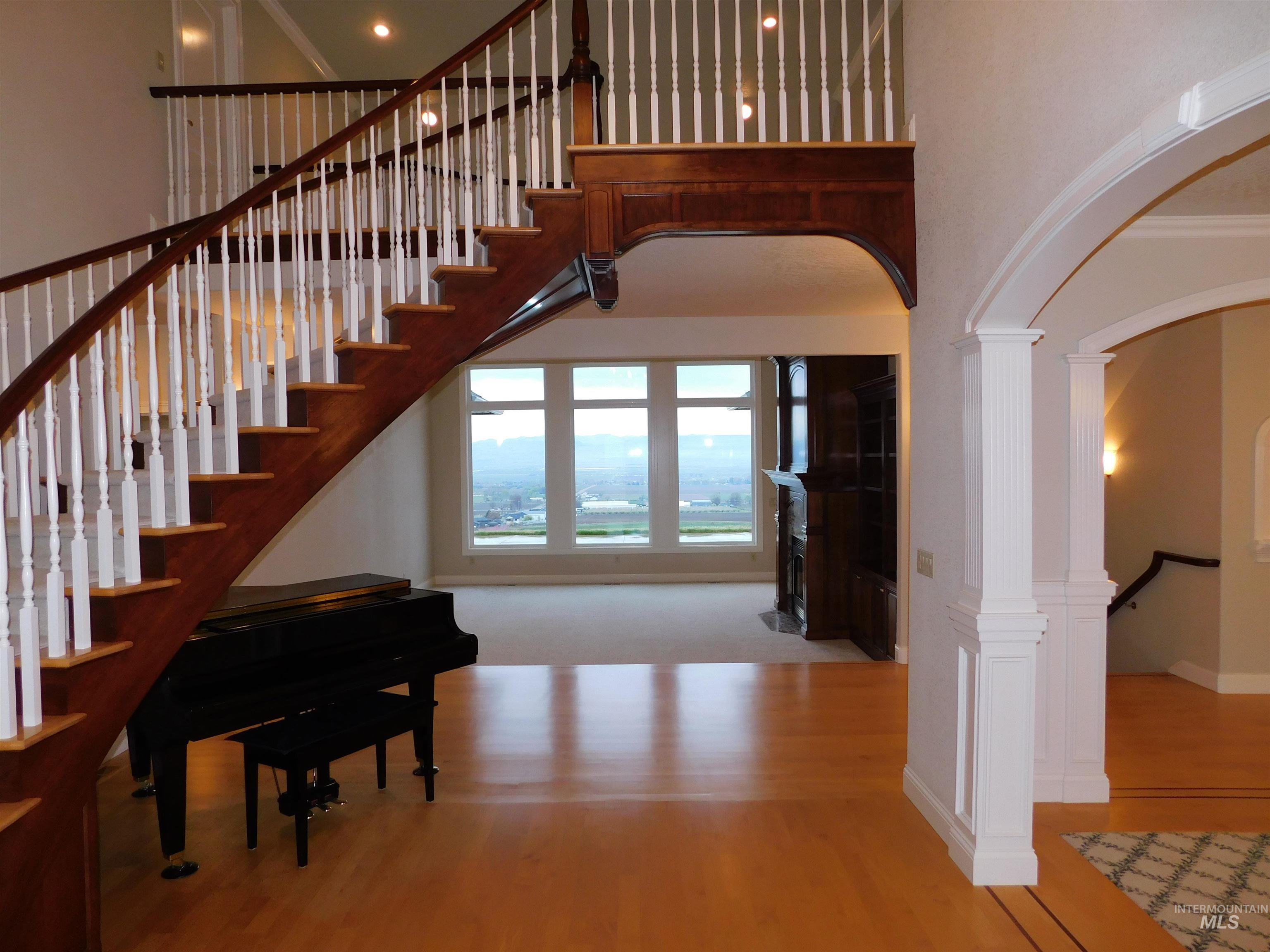 17777 Allendale Road Wilder, ID 83676 - Photo 4 of 50 Foyer entrance with arched walkways, hard wood floors, decorative columns, a high ceiling, and ornamental molding