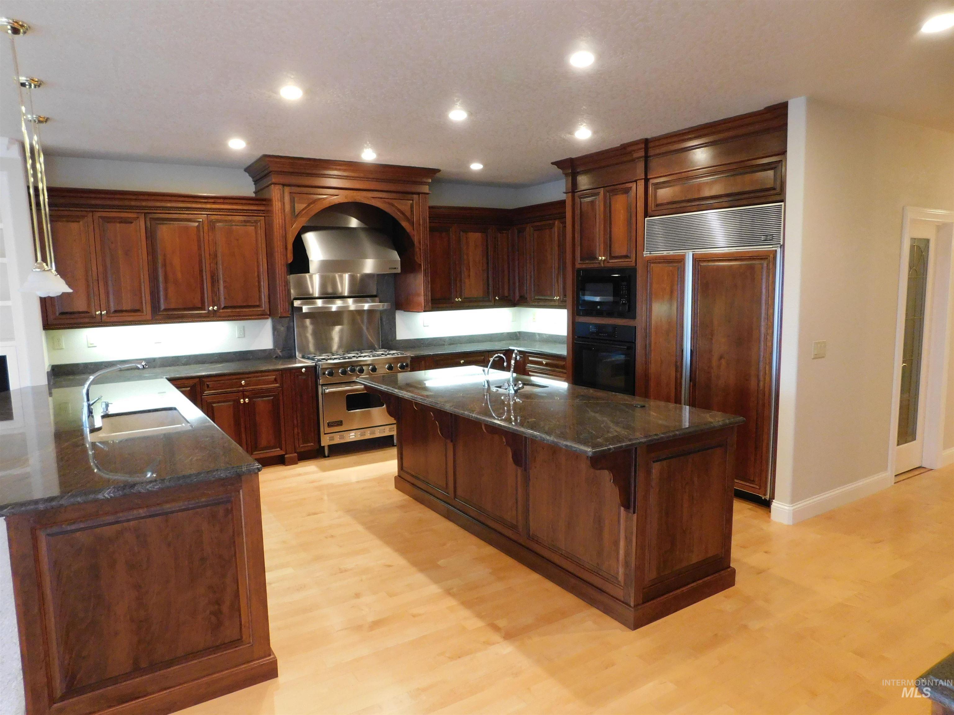 17777 Allendale Road Wilder, ID 83676 - Photo 9 of 50 Kitchen featuring recessed lighting, stainless appliances, a custom Cherry cabinets, dark stone counters, and hardwood floors.
