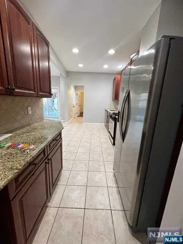 a kitchen with granite countertop stainless steel appliances a sink stove and refrigerator