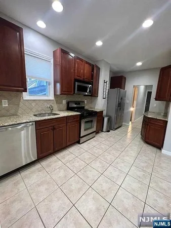 a kitchen with stainless steel appliances kitchen island granite countertop a sink and cabinets