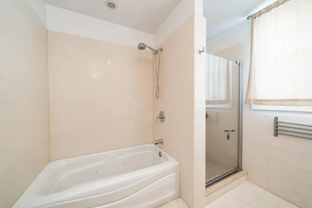 a white bath tub sitting next to a shower