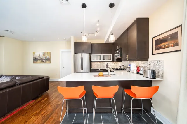 a kitchen with stainless steel appliances kitchen island granite countertop a sink and cabinets