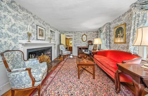 a living room with furniture a fireplace and next to a window
