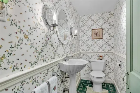 a bathroom with a sink toilet and a mirror