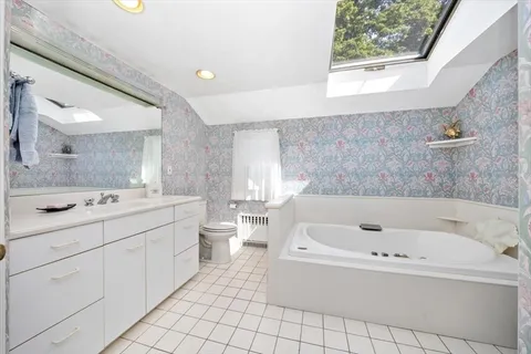 a bathroom with a bathtub a sink a vanity and a window
