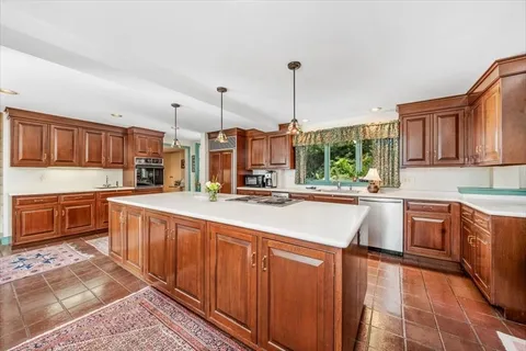 a kitchen with stainless steel appliances kitchen island granite countertop a sink and cabinets