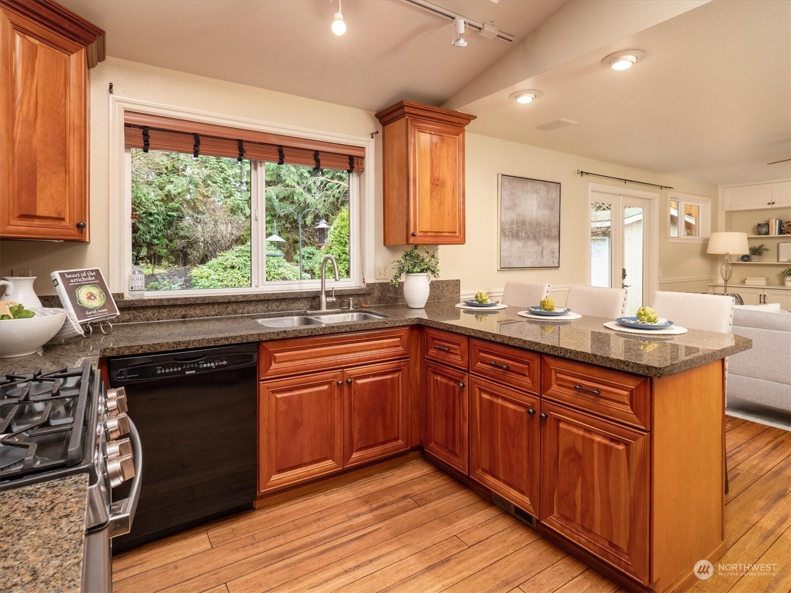 1622 243rd Place Southeast Bothell, WA 98021 - Photo 12 of 25 a kitchen with stainless steel appliances granite countertop wooden cabinets a sink and a large window