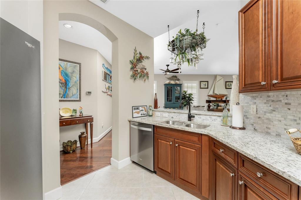 17094 Acapulco Road, Unit 321 Punta Gorda, FL 33955 - Photo 11 of 52 a kitchen with kitchen island granite countertop a sink stainless steel appliances and cabinets