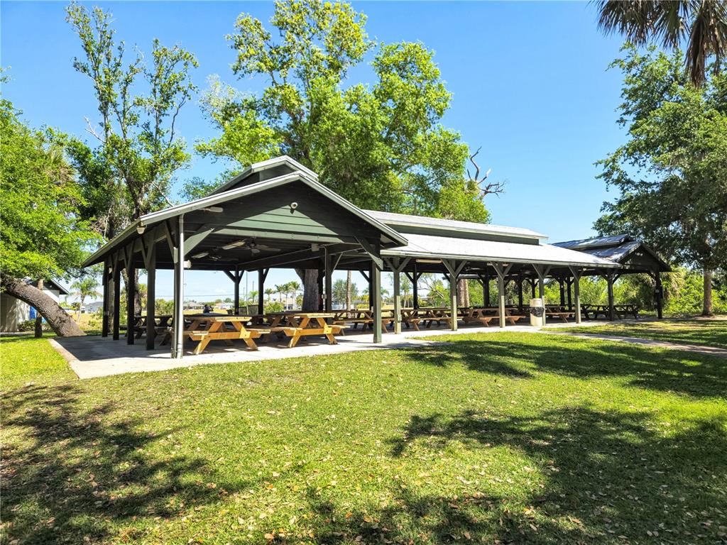 17094 Acapulco Road, Unit 321 Punta Gorda, FL 33955 - Photo 49 of 52 a view of a swimming pool with lawn chairs under an umbrella
