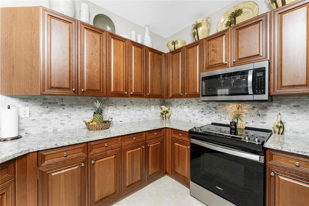 17094 Acapulco Road, Unit 321 Punta Gorda, FL 33955 - Photo 7 of 52 a kitchen with stainless steel appliances granite countertop a sink stove and microwave