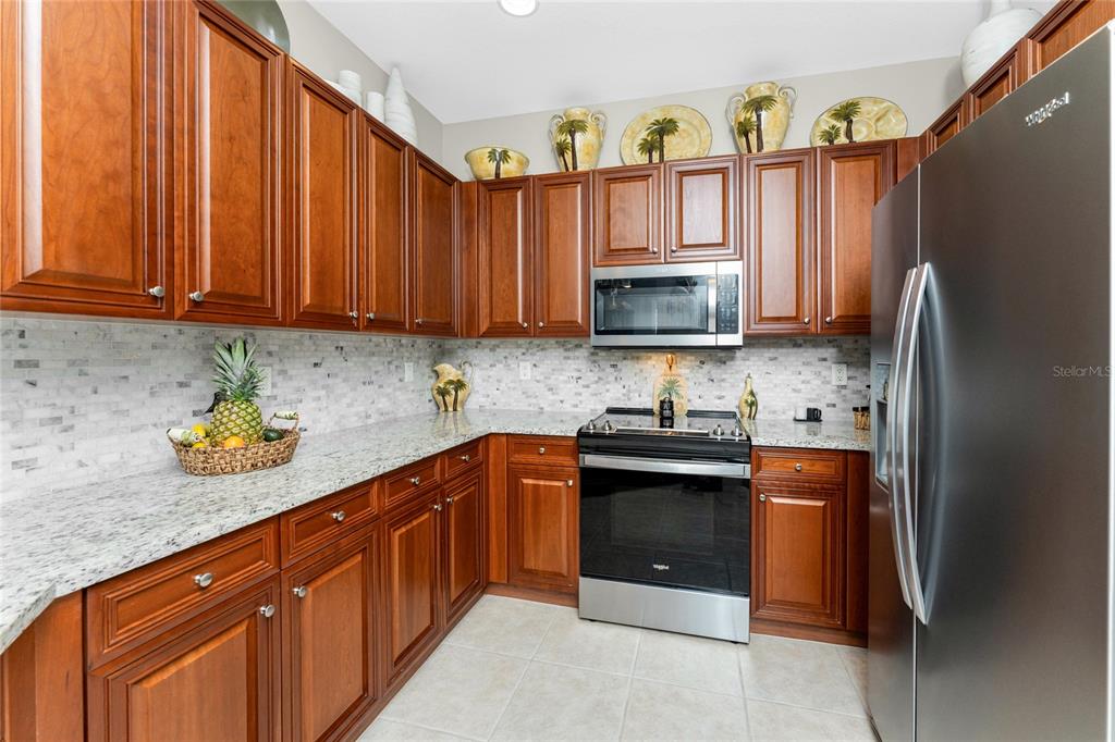 17094 Acapulco Road, Unit 321 Punta Gorda, FL 33955 - Photo 9 of 52 a kitchen with stainless steel appliances granite countertop a refrigerator stove and sink