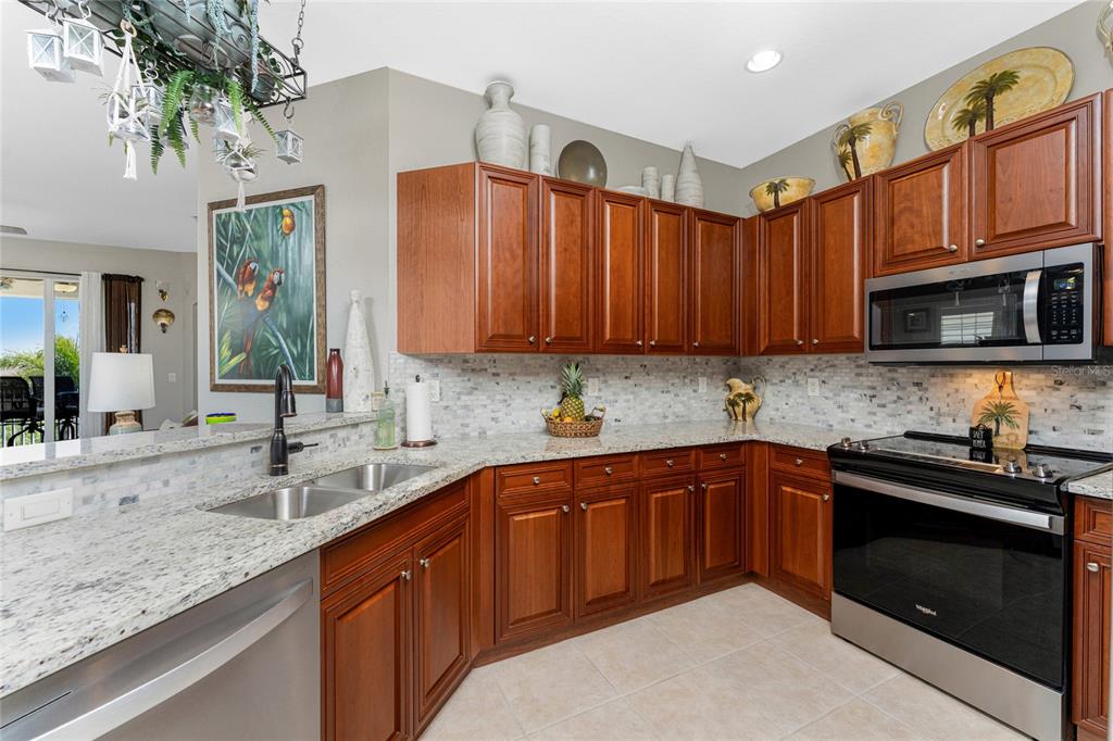 17094 Acapulco Road, Unit 321 Punta Gorda, FL 33955 - Photo 10 of 52 a kitchen with stainless steel appliances granite countertop a sink stove and microwave