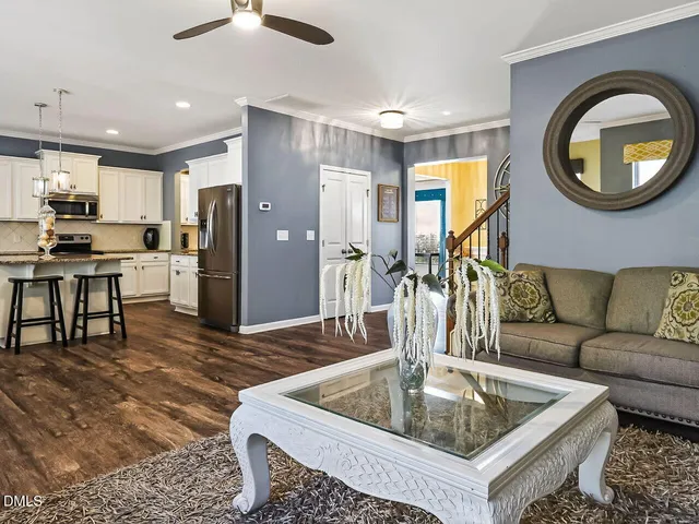 a living room with stainless steel appliances furniture stove and kitchen view