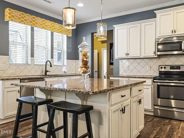 a kitchen with stainless steel appliances granite countertop a stove a sink and a refrigerator