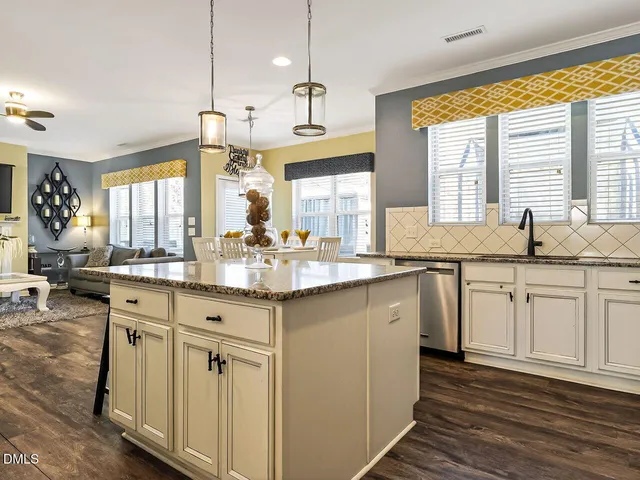 a kitchen with granite countertop white cabinets and a sink