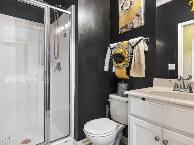 a bathroom with a toilet sink vanity and mirror