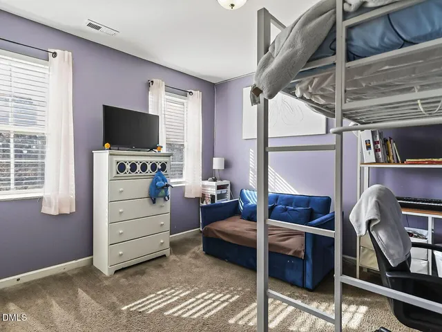 a bedroom with furniture and a flat screen tv