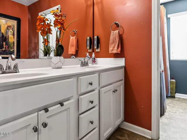 a bathroom with double vanity sink and a mirror