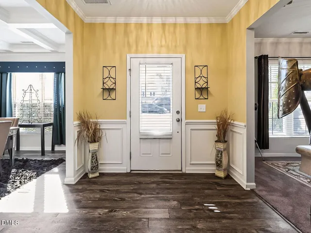 a view of a hallway with wooden floor and a living room