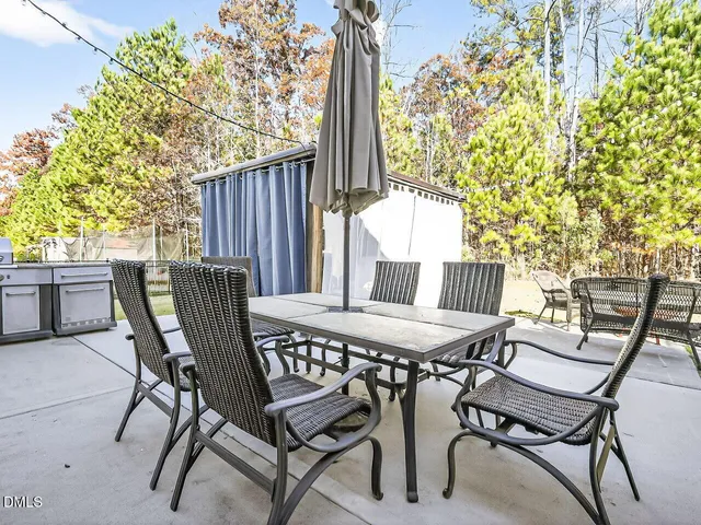 a view of a patio with table and chairs with wooden fence and plants