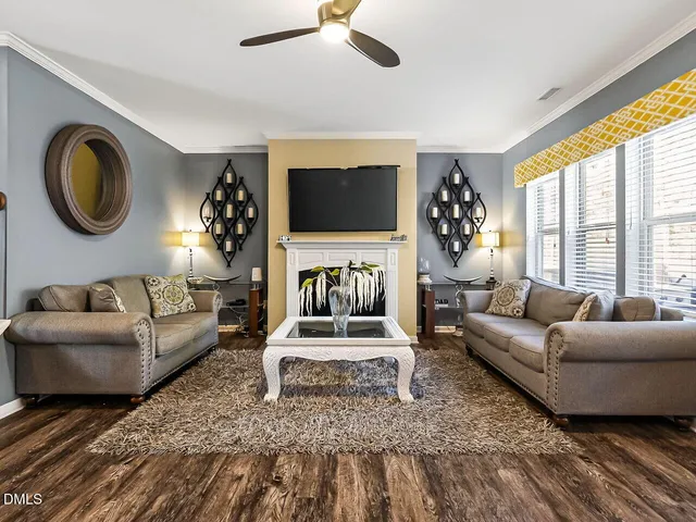 a living room with furniture a flat screen tv and a large window
