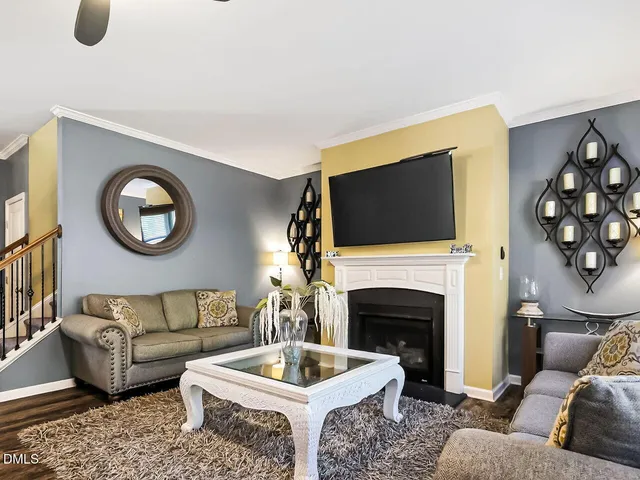 a living room with furniture a flat screen tv and a fireplace