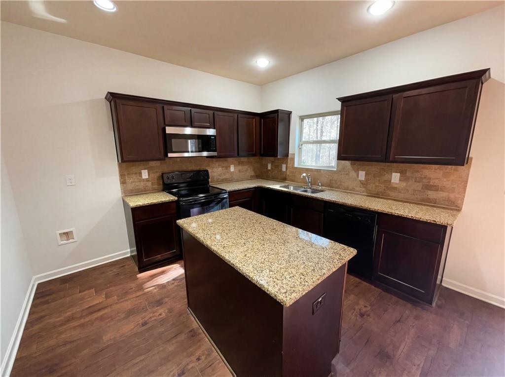 1209 Vienna Court Hampton, GA 30228 - Photo 2 of 21 a kitchen with stainless steel appliances granite countertop a sink stove and microwave