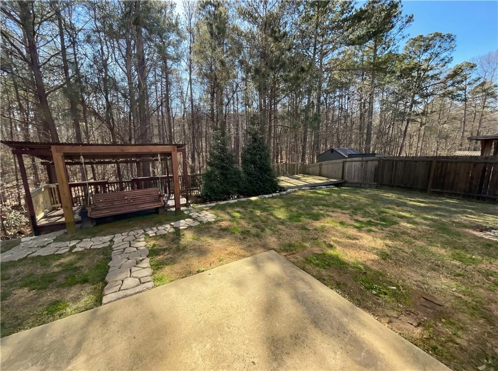 1209 Vienna Court Hampton, GA 30228 - Photo 21 of 21 a view of a backyard with wooden fence and trees