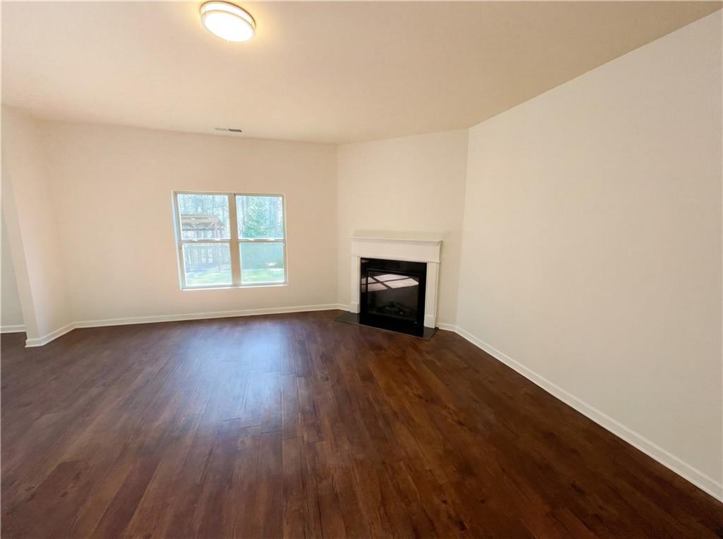 1209 Vienna Court Hampton, GA 30228 - Photo 3 of 21 an empty room with wooden floor fire place and windows