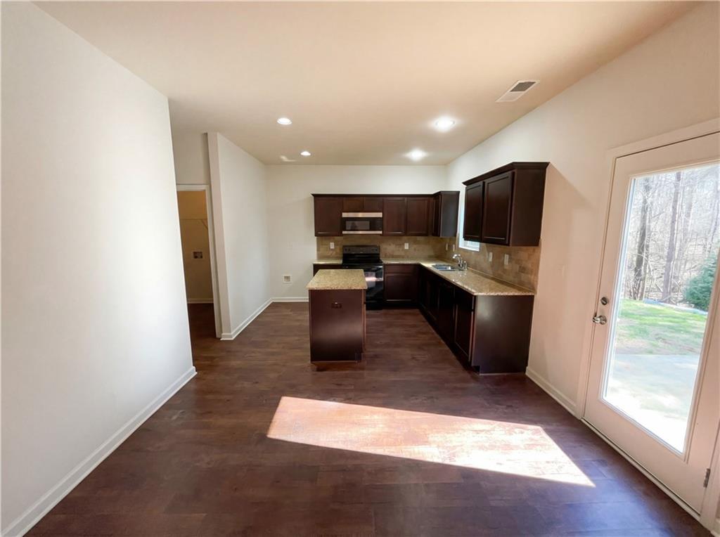 1209 Vienna Court Hampton, GA 30228 - Photo 9 of 21 a living room with stainless steel appliances kitchen island granite countertop a refrigerator and a sink