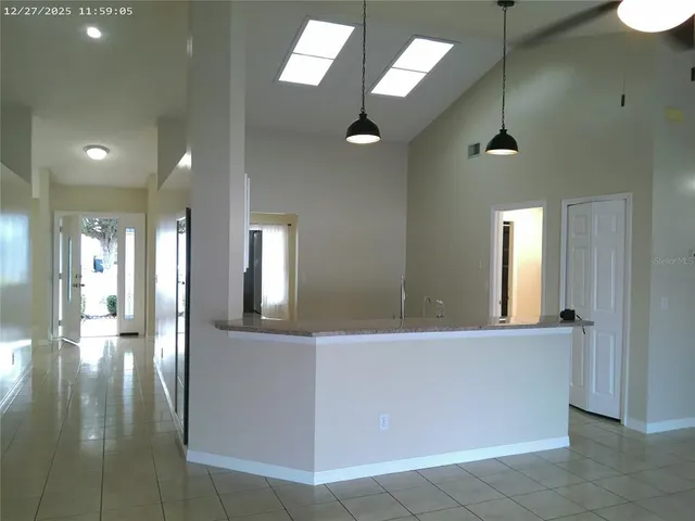 a view of a hallway with wooden floor and a bathroom