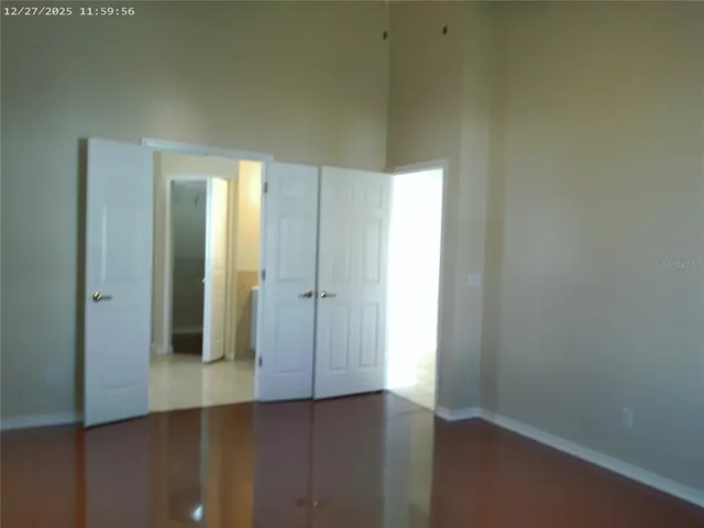 an empty room with wooden floor and closet