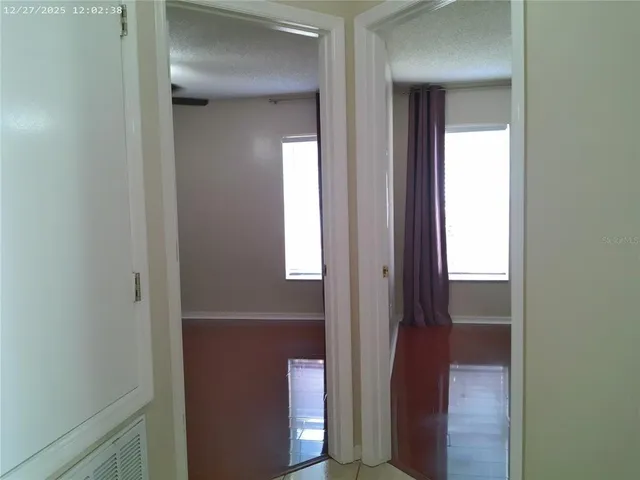 an empty room with windows and fan