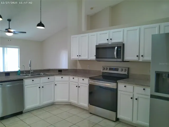 a kitchen with granite countertop a stove sink and cabinets