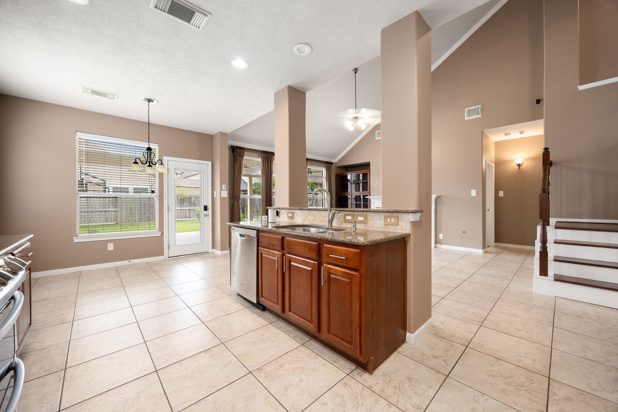 4526 Countrypines Drive Spring, TX 77388 - Photo 19 of 38 Functional kitchen island overlooking a sunlit breakfast nook with direct backyard access and durable tile flooring throughout.