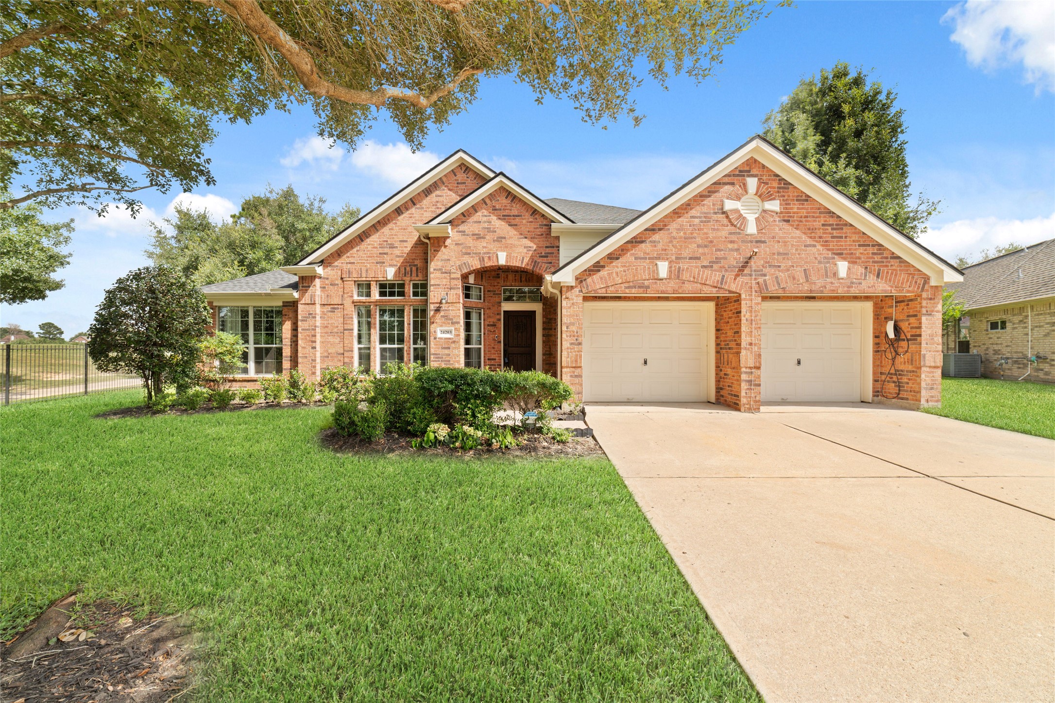 24203 Moon Ridge Court Katy, TX 77494 - Photo 2 of 43 The home features loads of curb appeal with mature landscaping, large windows, a gabled roof, and a welcoming front entryway.