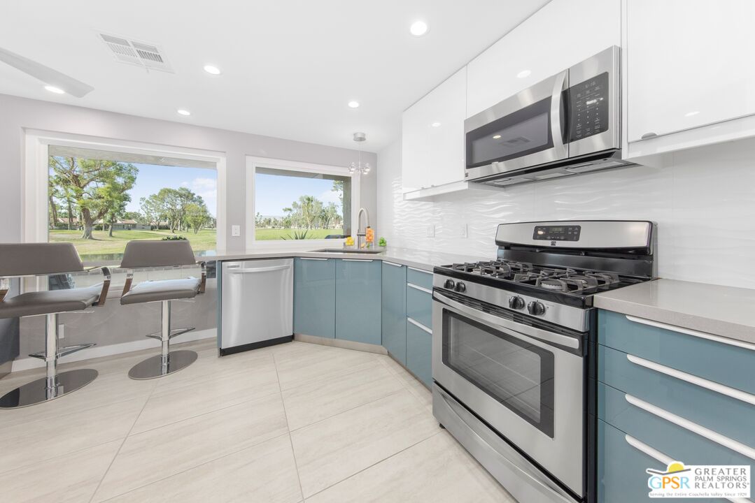 36022 Paseo Circulo West Cathedral City, CA 92234 - Photo 16 of 47 a kitchen with stainless steel appliances a stove microwave and sink