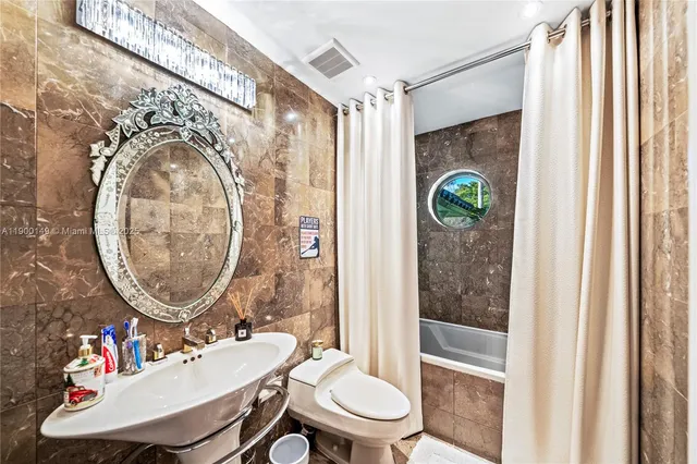 a bathroom with a sink mirror toilet and shower