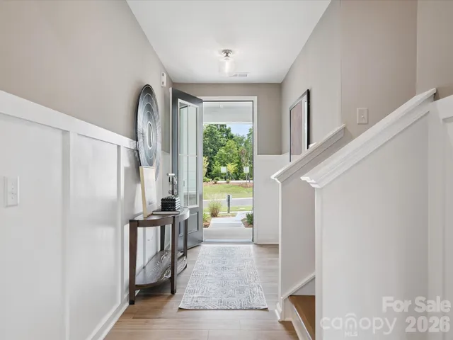 a kitchen with stainless steel appliances kitchen island granite countertop a stove top oven a sink a dining table and chairs with wooden floor