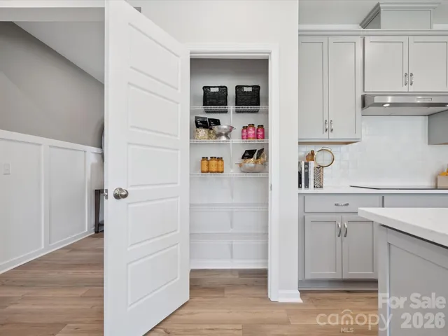 a living room with stainless steel appliances kitchen island granite countertop a large window and a view of kitchen