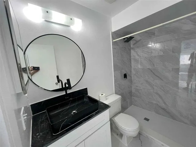 a bathroom with a sink a toilet and a mirror