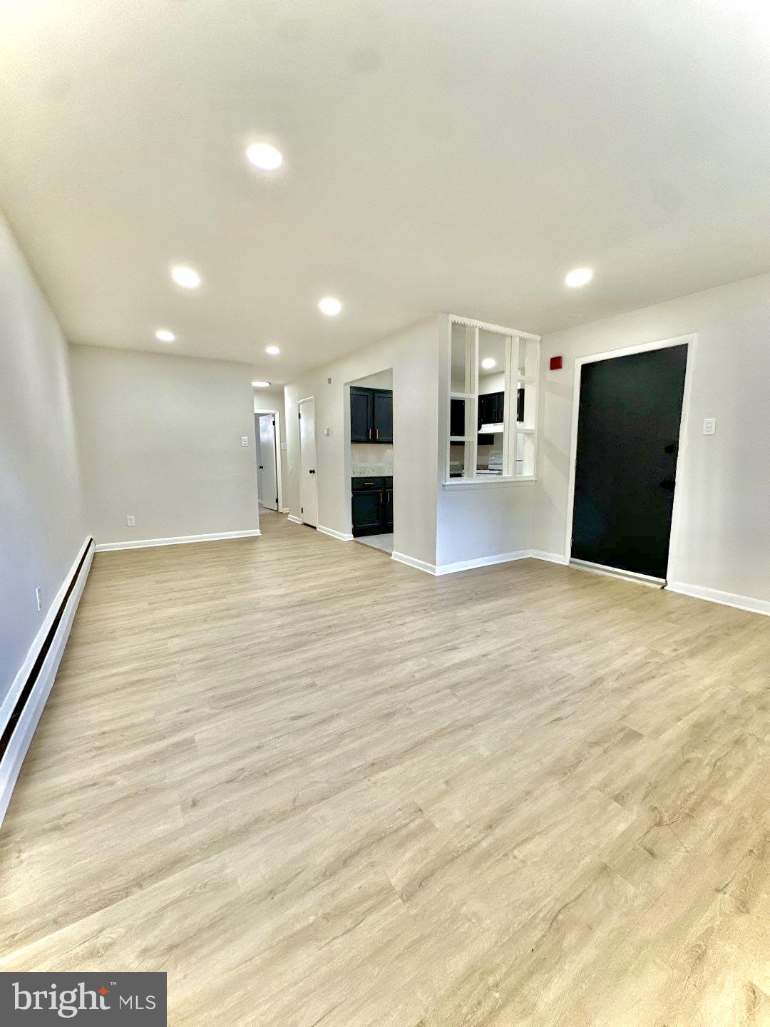 a view of a big room with wooden floor and windows