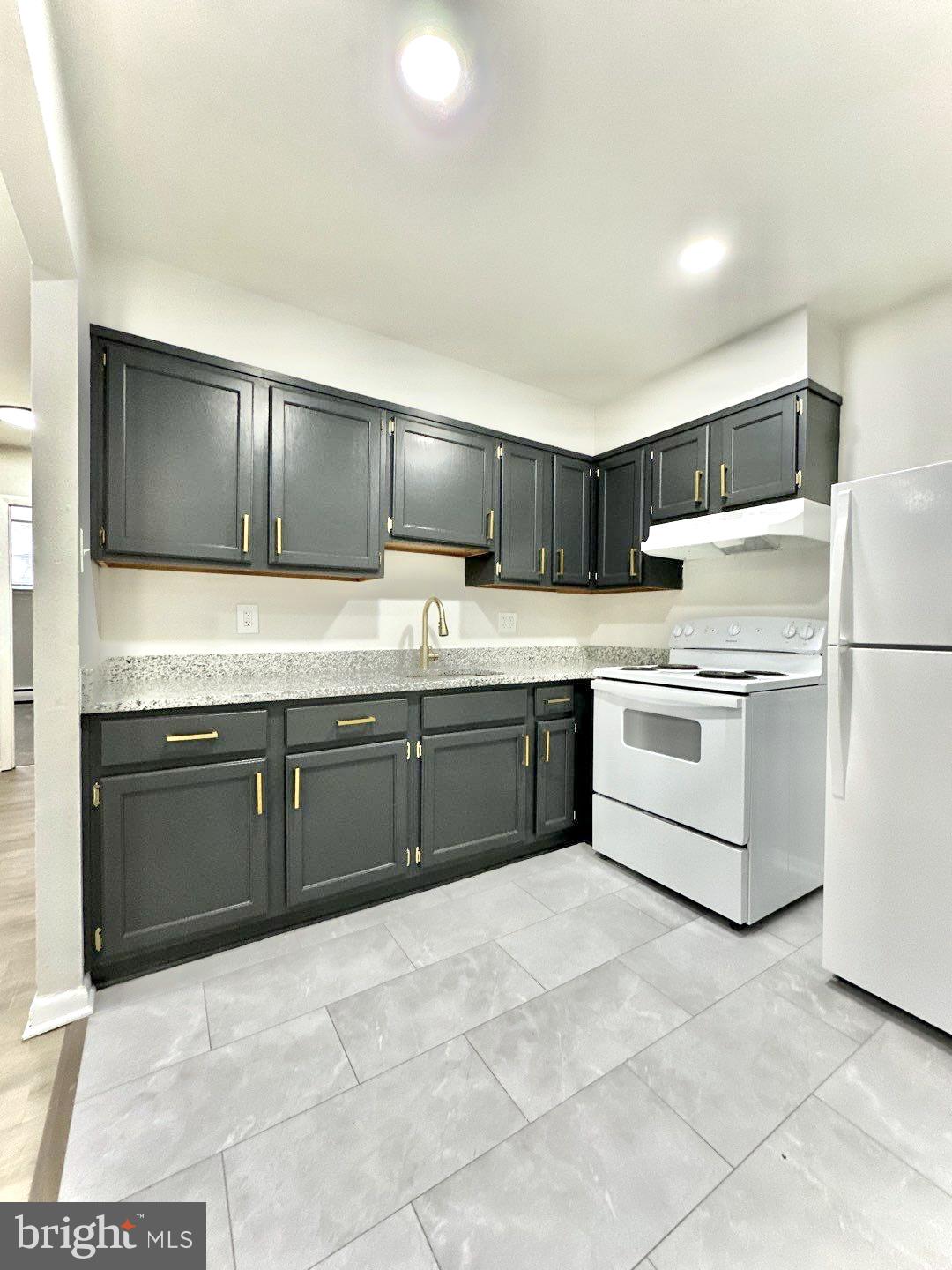 521 Martin Street, Unit A1 Philadelphia, PA 19128 - Photo 3 of 6 a kitchen with stainless steel appliances granite countertop a refrigerator sink and cabinets