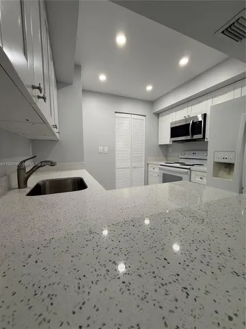 a kitchen with stainless steel appliances a refrigerator and a microwave