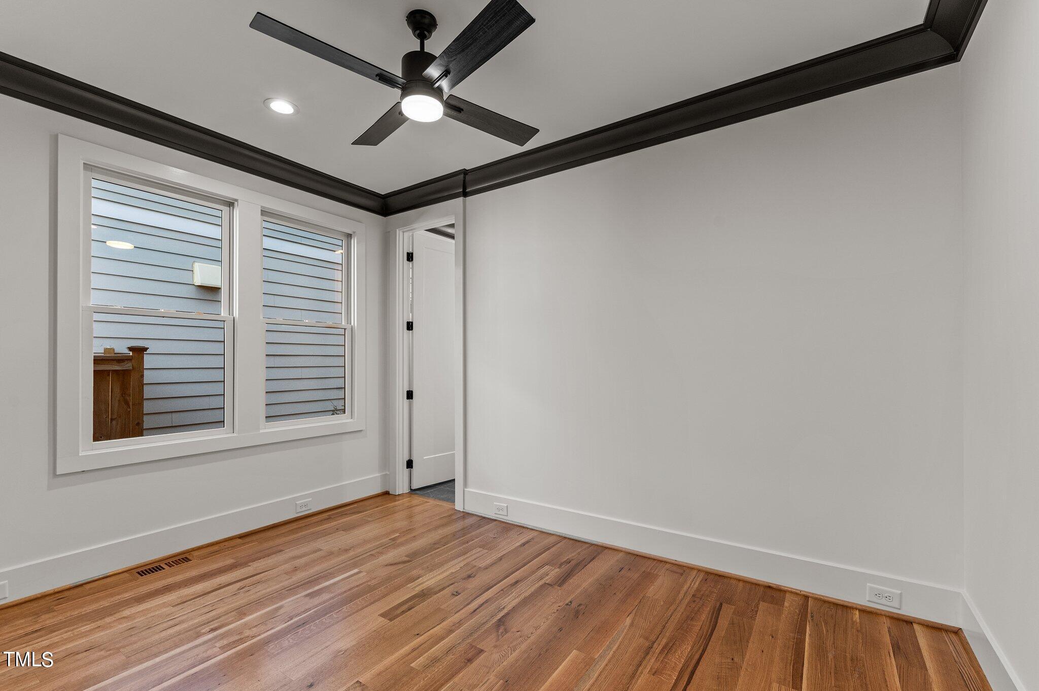 1437 Nottingham Road Raleigh, NC 27607 - Photo 22 of 61 a view of empty room with wooden floor and fan