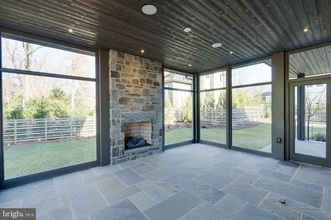 a view of an empty room with wooden floor and a fireplace
