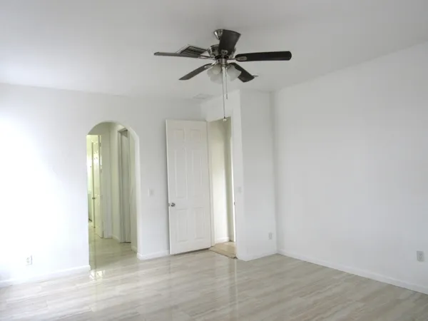 an empty room with a mirror and a ceiling fan